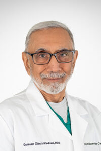 An older man in a lab coat posing for a photo.